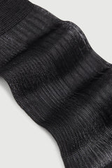 Close-up of a black sock with ribbed texture on a light gray background