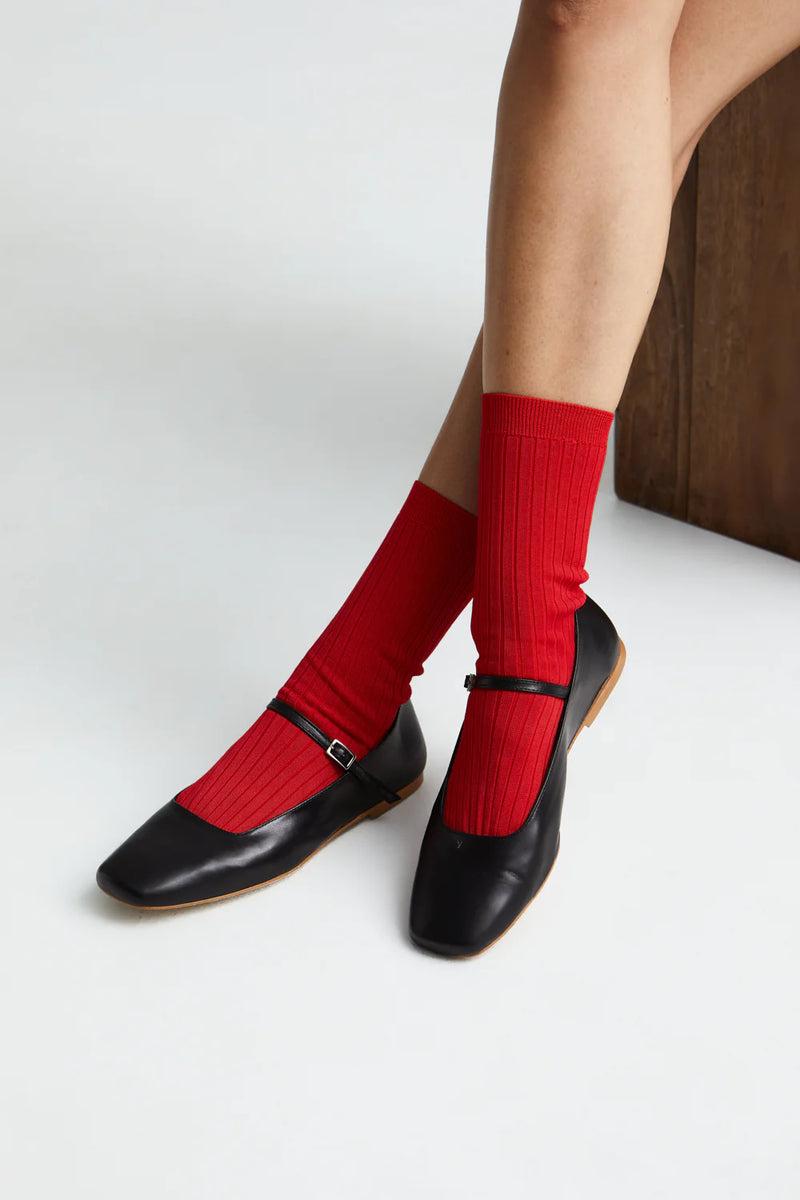 Red socks with black shoes on a white background