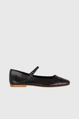 Black leather flat shoe with a strap on a white background