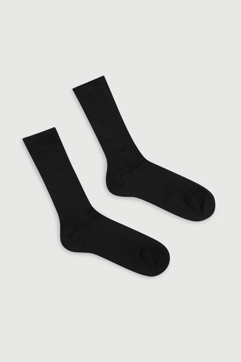 Two black socks on a light gray background