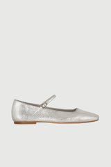 Silver flat shoe with a strap on a light gray background