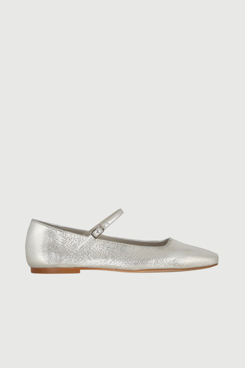 Silver flat shoe with a strap on a light gray background