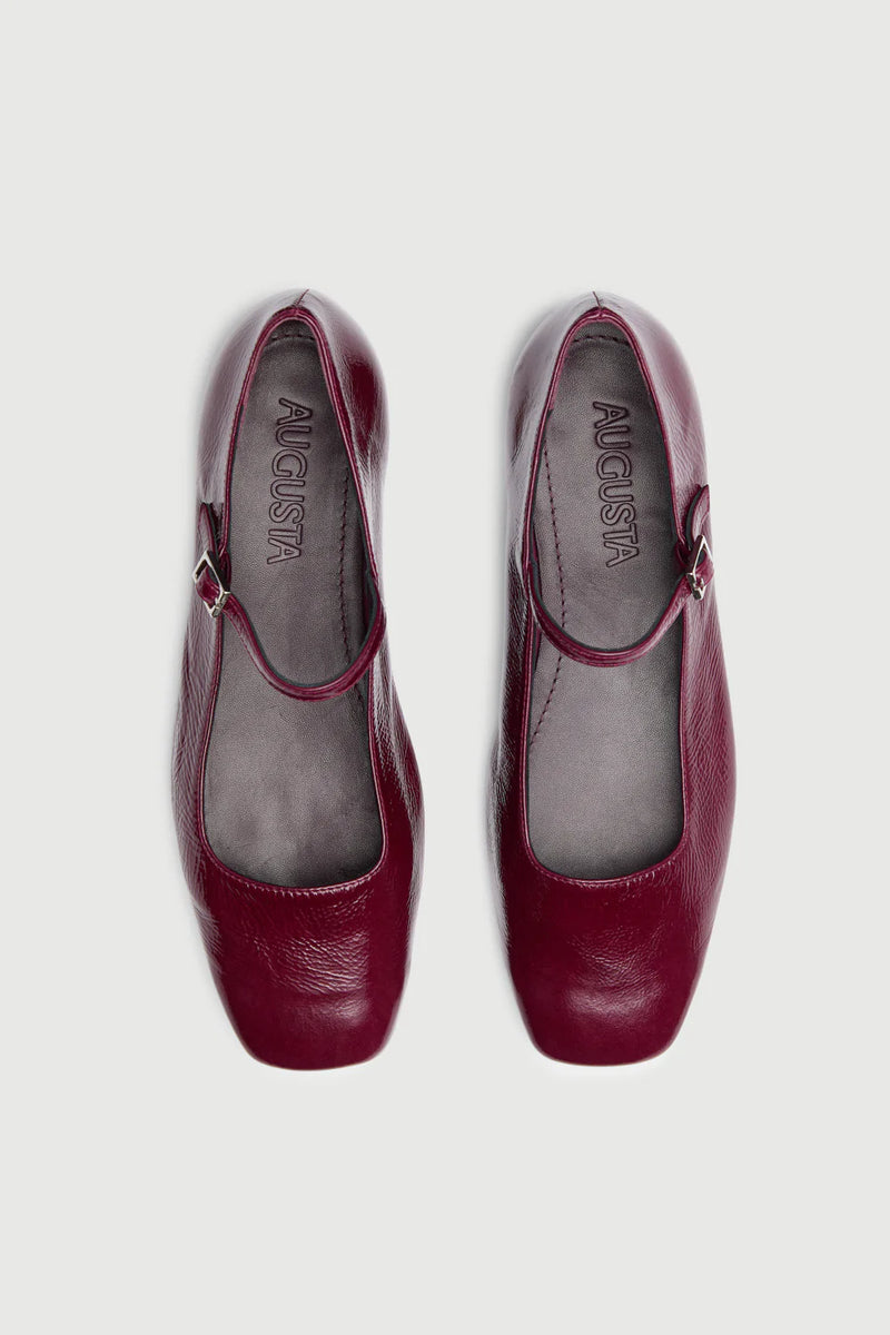 Pair of maroon shoes with 'August' branding on a white background