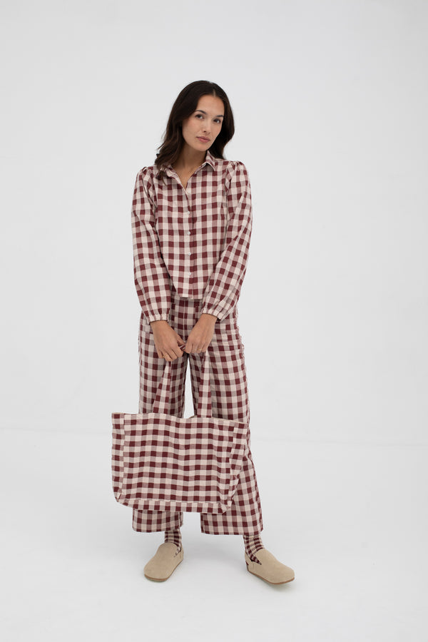 Woman wearing a red and white checkered outfit on a white background