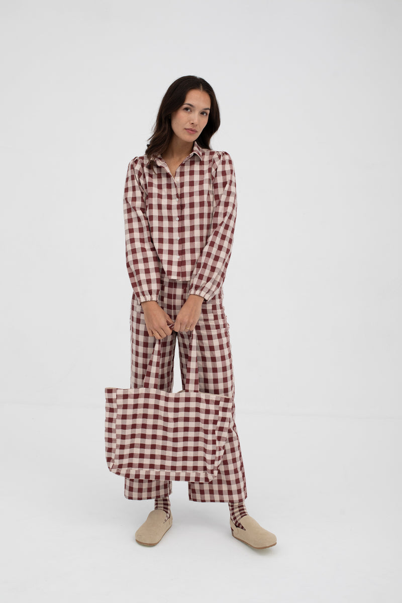 Woman wearing a red and white checkered outfit on a white background