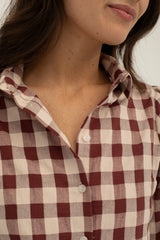 Close-up of a person wearing a red and white checkered shirt.