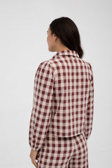 Person wearing a red and white checkered shirt and pants on a white background