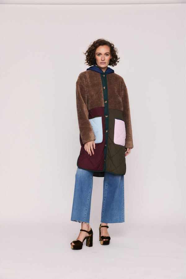 Woman wearing a colorful coat with a white background