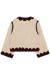 Beige sweater with brown scalloped edges on a white background
