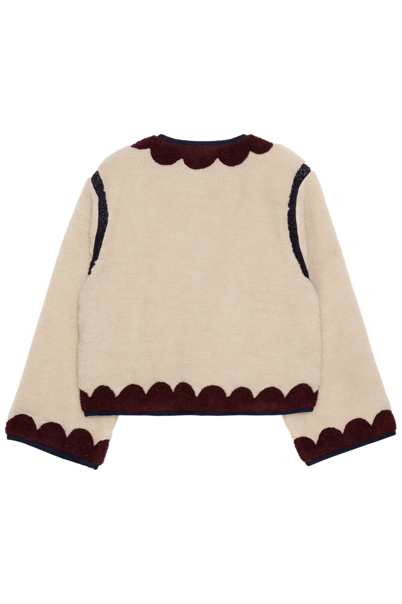 Beige sweater with brown scalloped edges on a white background