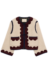 Knitted cardigan with scalloped edges on a white background