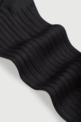 Stack of black socks on a light gray background