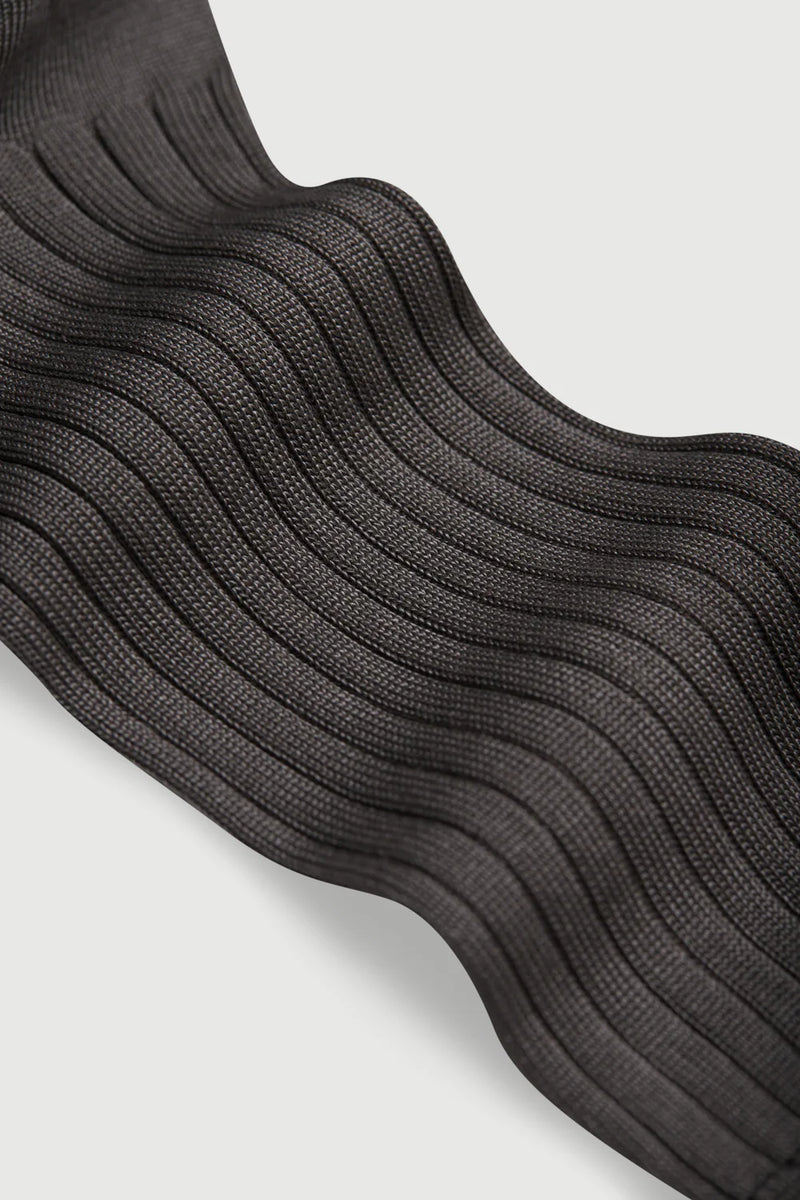 Close-up of black ribbed socks on a light gray background